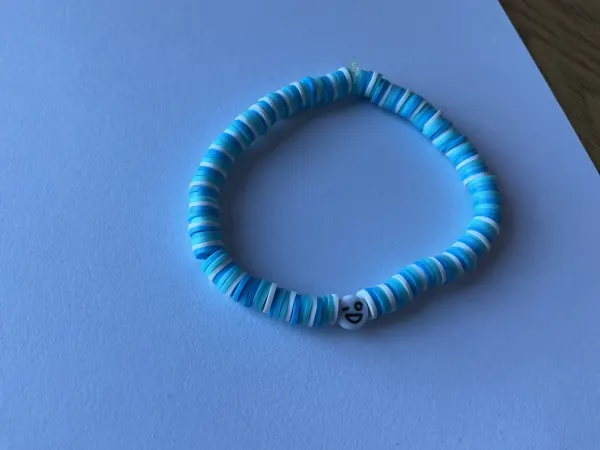 Pulsera con colores  azules y carita alegre