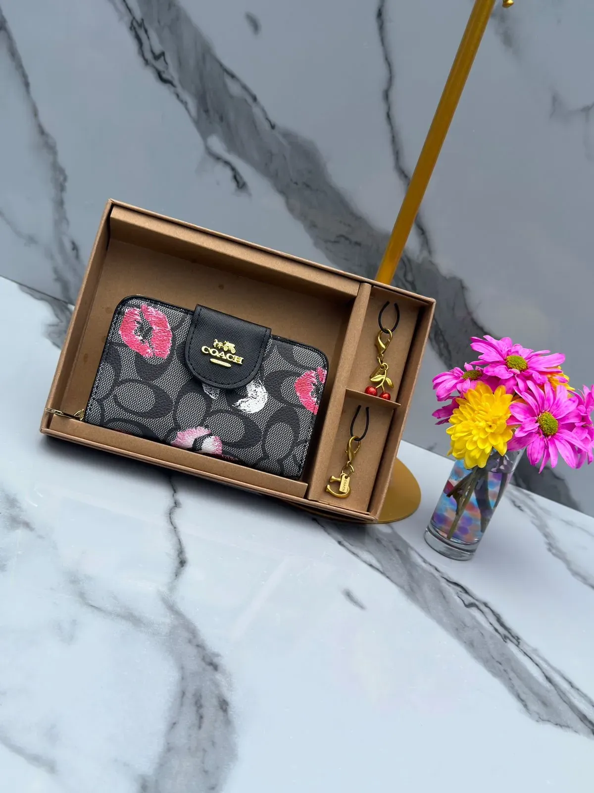 Billetera Coach Negra con Estampado Floral y Accesorios